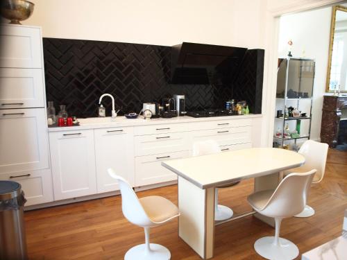 a kitchen with a white table and white chairs at Villa Casablanca Vichy Paris in Vichy