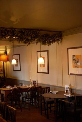 a dining room with tables and chairs and lights at The Grosvenor Arms in Hindon
