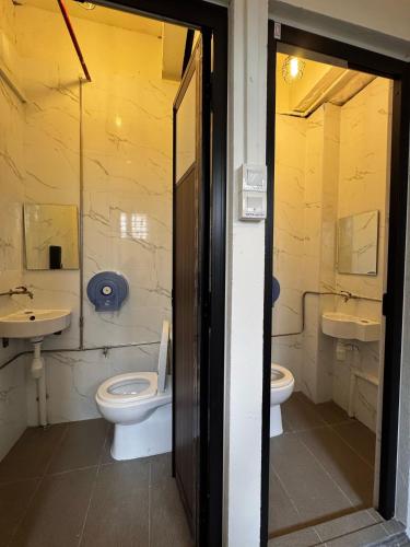 a bathroom with two sinks and two toilets at BEAT. Capsule Hostel @ Boat Quay in Singapore