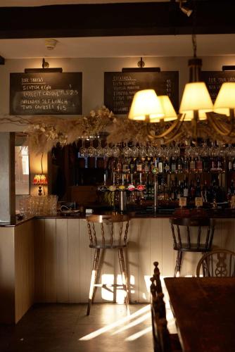 a bar with a lot of glasses on the wall at The Grosvenor Arms in Hindon