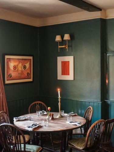 a dining room with a table with a candle on it at The Grosvenor Arms in Hindon