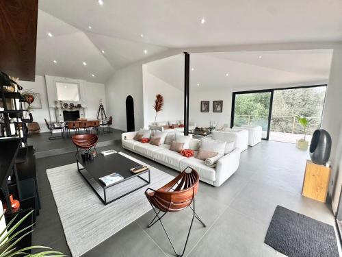 un salon avec un canapé blanc et une table dans l'établissement Villa avec piscine 14 personnes - Pinarello, à La Celle-sous-Gouzon