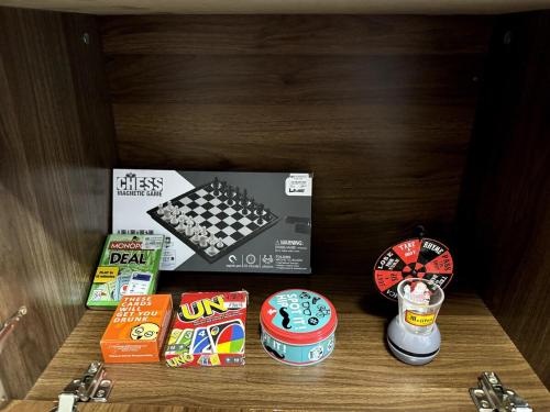 a shelf with a chess board and other toys in a drawer at Cozy 3BR Bungalow House with Netflix & Games in Davao City