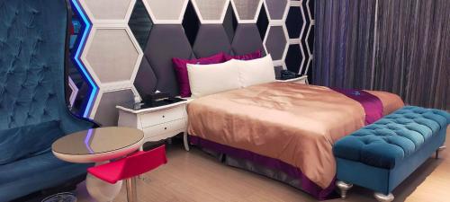 a bedroom with a bed and a blue chair at Icloud Luxury Resort & Hotel in Taichung