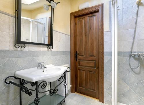 a bathroom with a sink and a mirror and a shower at Las Fuentes de Mena - Escape in Nature in Lezana de Mena