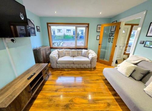 a living room with a couch and a table at Super luxury 2 bedroom, full house sleep 5 with garden & parking close to airport in Elderslie