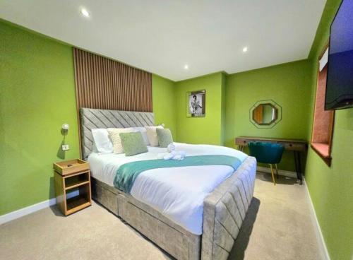 a bedroom with green walls and a bed with a teddy bear on it at Super luxury 2 bedroom, full house sleep 5 with garden & parking close to airport in Elderslie