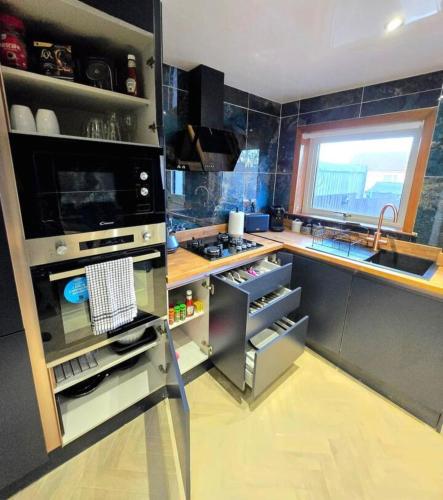 a kitchen with a stainless steel refrigerator with an open drawer at Super luxury 2 bedroom, full house sleep 5 with garden & parking close to airport in Elderslie