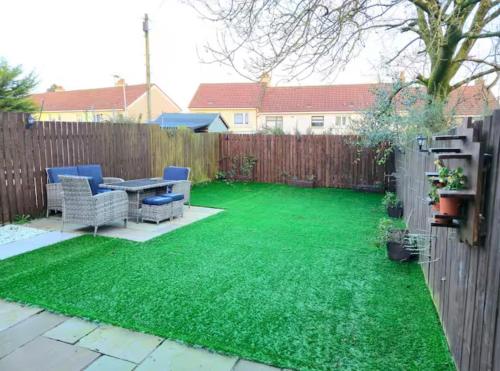 a backyard with green grass and a table and chairs at Super luxury 2 bedroom, full house sleep 5 with garden & parking close to airport in Elderslie