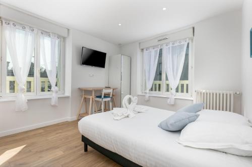 une chambre blanche avec un lit et deux fenêtres dans l'établissement Chambre indépendante Recouvrance, à Brest