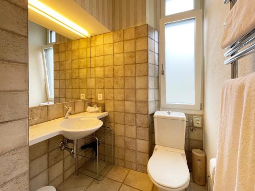 a bathroom with a toilet and a sink and a mirror at Ristorante della Stazione da YanElo in Intragna