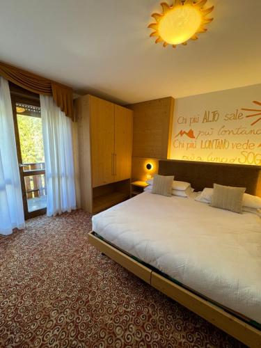 a hotel room with two beds and a window at Hotel Europa in San Martino di Castrozza