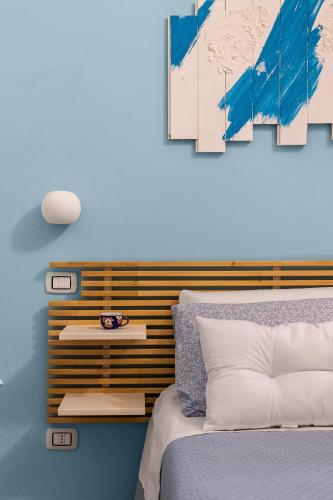 a bedroom with a bed and a blue wall at Madre Terra Airport Apartment & Rooms in Terrasini