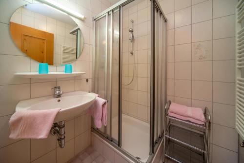 y baño con lavabo y ducha con toallas rosas. en Allgäuer Bergblick, en Fischen
