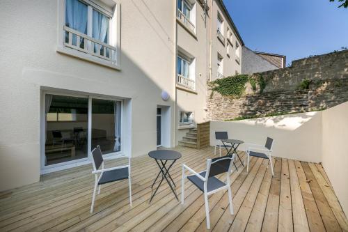 un patio avec des chaises et une table sur une terrasse en bois dans l'établissement Chambre indépendante La Bergère de Domrémy, à Brest