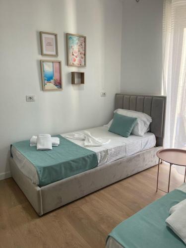 a bedroom with two beds and a table at Cozy Apartment near Center in Lezhë