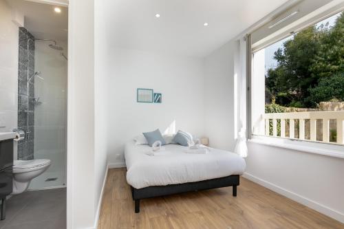 une chambre blanche avec un lit et une fenêtre dans l'établissement Chambre indépendante Bellepoule, à Brest