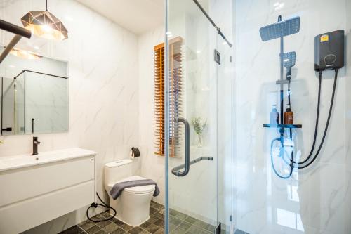 a bathroom with a shower and a toilet and a sink at Black Rocher Poolvilla Huahin in Hua Hin