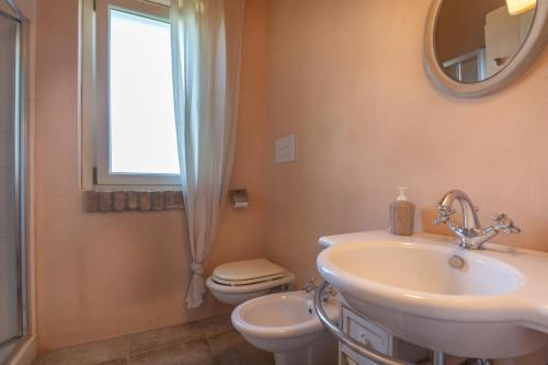 a bathroom with a sink and a toilet and a mirror at La Bella Addormentata in Castilenti