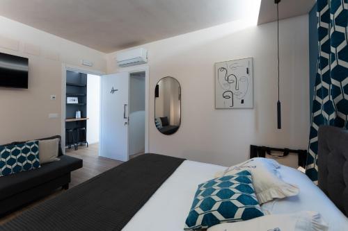 a bedroom with a bed and a couch at Tre Gemme in Centro - Suite Azure in Pescara