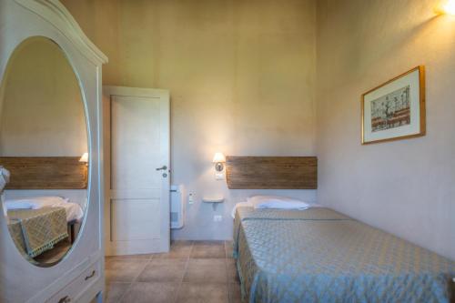 a small room with two beds and a mirror at La Bella Addormentata in Castilenti