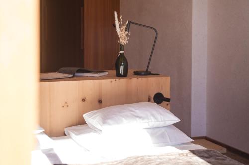 a bedroom with a bed and a vase with flowers at Farmhotel Moosmair in Campo Tures