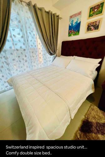 a bed with a white comforter in a bedroom at E4 Condotel CDO in Cagayan de Oro