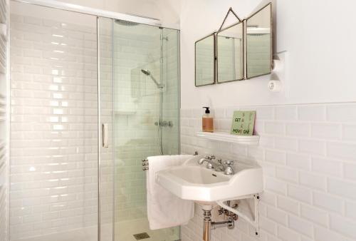 a white bathroom with a sink and a shower at Villa Casablanca Vichy Paris in Vichy