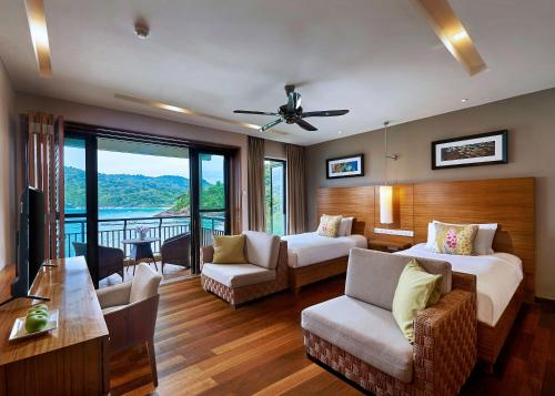 a living room with two beds and a balcony at The Taaras Beach & Spa Resort in Redang Island