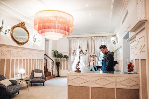 a man standing at a counter in a salon at GRANDE HOTEL PARIS by STAY HOTELS in Porto