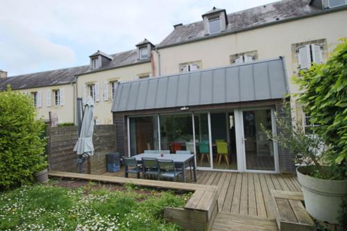 une maison avec une terrasse et une table. dans l'établissement Maison des Cordeliers, à Bayeux
