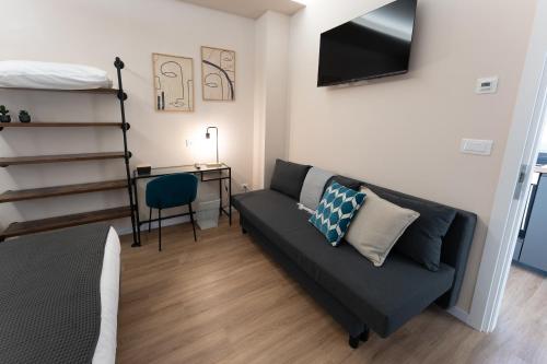 a living room with a couch and a desk at Tre Gemme in Centro - Suite Azure in Pescara