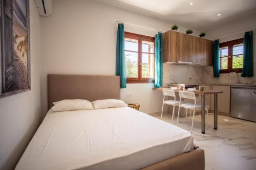 a bedroom with a bed and a kitchen with a table at Sunny Sofi Studios in Plános