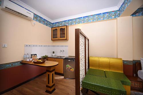 a room with a kitchen and a table with a chair at Tibet Boutique Hotel in Kathmandu
