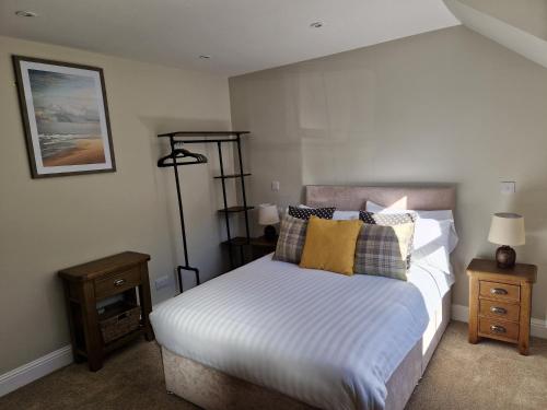 a bedroom with a bed with white sheets and pillows at The Dornie in Dornie
