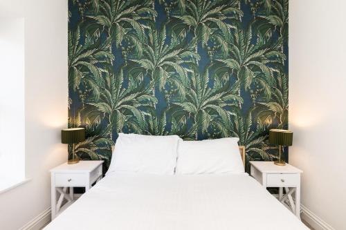 a bedroom with a large bed with a blue and green wallpaper at Large Groups Stays 12 Beds Whole Building in Reading