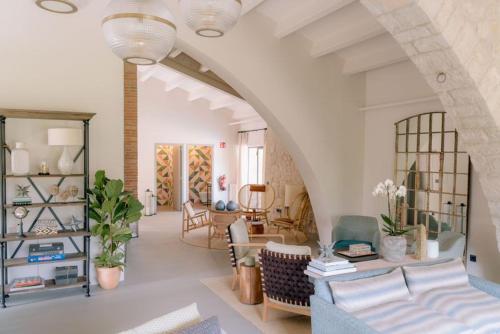 Una sala de estar con un arco con un sofá y sillas. en Artu Lodge, Can Terrades, en Beuda