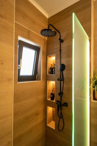 a shower in a bathroom with wooden walls and a window at Olive-Luxury apartment in agrinio in Agrinion
