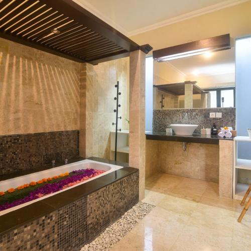a bathroom with a tub and a sink at Villa EL Noya Umallas in Badung