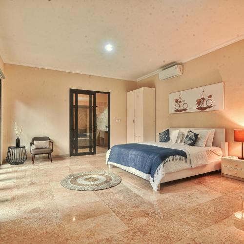 a bedroom with a large bed and a chair at Villa EL Noya Umallas in Badung