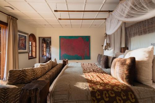a living room with a couch and a bed at Hemingways Eden Residence in Nairobi