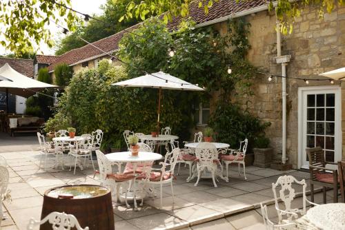 a patio with tables and chairs and an umbrella at The Grosvenor Arms in Hindon