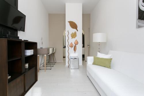 a living room with a white couch and a table at Aparthotel Dei Mercanti in Milan