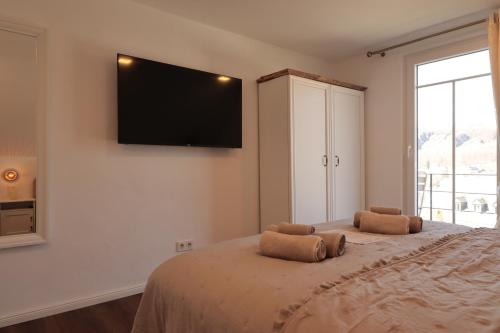 a bedroom with a large bed with a flat screen tv on the wall at Ferienhaus Unter der Burg in Gerolstein