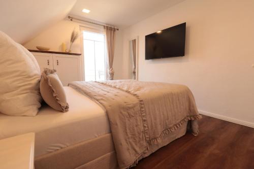 a bedroom with a bed with a television on the wall at Ferienhaus Unter der Burg in Gerolstein