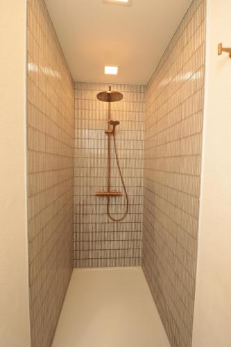 a walk in shower with a shower head at Ferienhaus Unter der Burg in Gerolstein