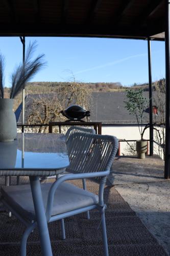 a table and a chair on a patio with a view at Ferienhaus Unter der Burg in Gerolstein