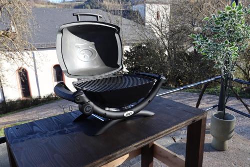 a black and silver grill sitting on a wooden table at Ferienhaus Unter der Burg in Gerolstein