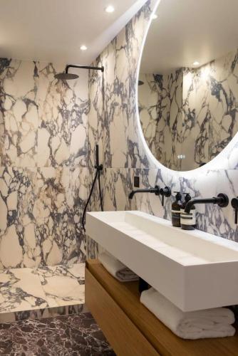 une salle de bain avec un lavabo blanc et un miroir dans l'établissement Splendid Apartment 2BR 6P Near Palais Royal, à Paris