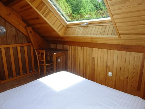 Habitación en el ático con cama y ventana en Les Oulles 19, en La Chapelle-en-Valgodemard